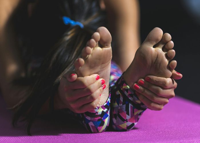 Detailed close-up of a person practicing stretching exercises on a mat.